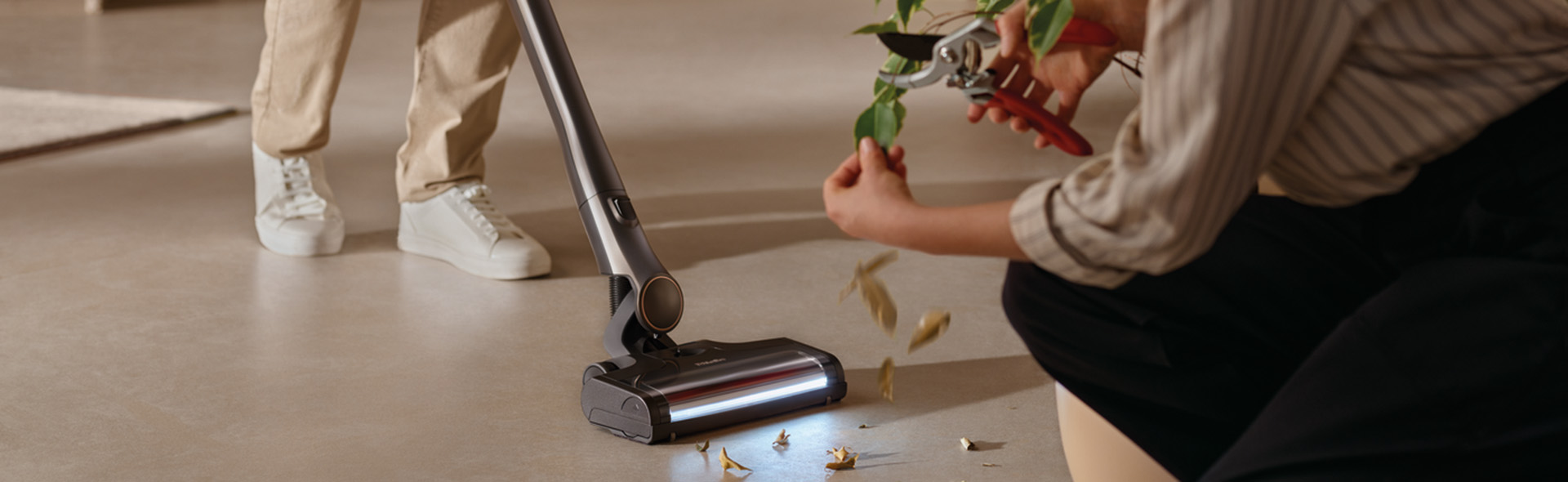 Person schneidet Blätter welche eine andere Person aufsaugt